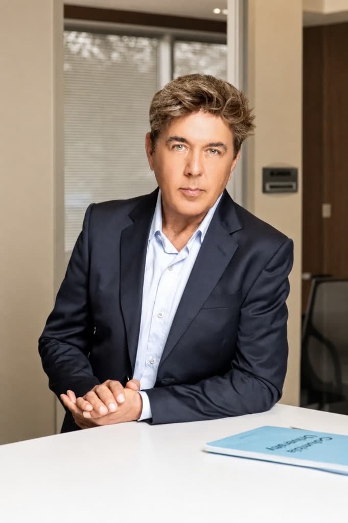 Sam, founder of CollegePrep, seated at a desk in a navy blazer
